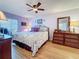 Cozy bedroom with a ceiling fan, hardwood floors, and a comfortable queen-sized bed at 4725 Cove Circle # 908, St Petersburg, FL 33708
