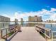View from a wooden dock on the building property, looking towards the condo complex and a blue sky at 4725 Cove Circle # 908, St Petersburg, FL 33708