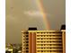 Condo exterior featuring a vibrant rainbow over a multi-story building, showcasing stunning views at 4725 Cove Circle # 908, St Petersburg, FL 33708
