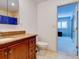 Bathroom features a wooden vanity with granite countertop and a door to the bedroom at 504 Riverside Dr # 504, Tarpon Springs, FL 34689
