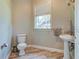 Cozy bathroom features pedestal sink, toilet, wood-look flooring and window at 504 Riverside Dr # 504, Tarpon Springs, FL 34689
