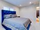 Light-filled bedroom with a blue upholstered bed and a view into the attached bathroom, creating a serene retreat at 504 Riverside Dr # 504, Tarpon Springs, FL 34689