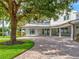 Circular brick driveway leading to a beautiful home with a covered patio and lush landscaping at 504 Riverside Dr # 504, Tarpon Springs, FL 34689