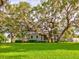Expansive green lawn and mature trees, complementing the home's exterior and creating an inviting outdoor space at 504 Riverside Dr # 504, Tarpon Springs, FL 34689