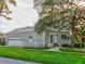 Charming two-story home with a brick exterior, lush green lawn, and mature trees creating a picturesque setting at 504 Riverside Dr # 504, Tarpon Springs, FL 34689