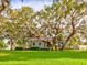 Expansive green lawn and mature trees, complementing the home's exterior and creating an inviting outdoor space at 504 Riverside Dr # 504, Tarpon Springs, FL 34689