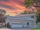 View of the home's side showcasing the attached two-car garage, fenced-in area, and well-maintained landscaping at 504 Riverside Dr # 504, Tarpon Springs, FL 34689
