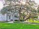 Charming two-story home with a brick exterior, lush green lawn, and mature trees creating a picturesque setting at 504 Riverside Dr # 504, Tarpon Springs, FL 34689