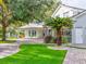 Exterior shot of a well-manicured lawn with a palm tree in the foreground of this light gray home at 504 Riverside Dr # 504, Tarpon Springs, FL 34689