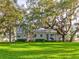 Expansive green lawn and mature trees, complementing the home's exterior and creating an inviting outdoor space at 504 Riverside Dr # 504, Tarpon Springs, FL 34689