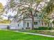 Charming two-story home with a brick exterior, lush green lawn, and mature trees creating a picturesque setting at 504 Riverside Dr # 504, Tarpon Springs, FL 34689