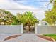Image of a well-kept home beyond a decorative privacy wall and stately black iron gate at 504 Riverside Dr # 504, Tarpon Springs, FL 34689