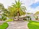 Stunning home with a circular brick driveway, mature palm tree, and lush green lawn at 504 Riverside Dr # 504, Tarpon Springs, FL 34689
