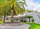 Landscaped front yard with a brick driveway, palm tree, and views of the elegant home at 504 Riverside Dr # 504, Tarpon Springs, FL 34689