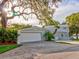 Exterior features an oversized garage with multiple bays and meticulously landscaped grounds at 504 Riverside Dr # 504, Tarpon Springs, FL 34689