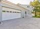 View of the home's two-car garage, with well-maintained landscaping and a paved driveway at 504 Riverside Dr # 504, Tarpon Springs, FL 34689