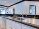 Kitchen sink with granite countertops, white cabinets, stainless steel faucet, and wood plank flooring at 504 Riverside Dr # 504, Tarpon Springs, FL 34689
