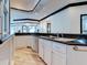 Kitchen with granite countertops, stainless sink, white cabinetry, and wood plank floors at 504 Riverside Dr # 504, Tarpon Springs, FL 34689