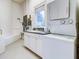Well-lit laundry room featuring a stacked washer and dryer, countertop, and window at 504 Riverside Dr # 504, Tarpon Springs, FL 34689