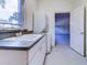 Bright laundry room with a view, featuring a sink, stacked washer/dryer, and garage access at 504 Riverside Dr # 504, Tarpon Springs, FL 34689