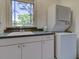 Cozy laundry room with a stacked washer and dryer and speckled counter at 504 Riverside Dr # 504, Tarpon Springs, FL 34689