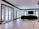 Open-concept living room with dark trim, light floors, shutters, and french doors at 504 Riverside Dr # 504, Tarpon Springs, FL 34689