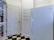 Pantry with open shelving, black and white flooring, white refrigerator and doorway at 504 Riverside Dr # 504, Tarpon Springs, FL 34689