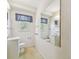 Neutral-toned bathroom includes a tile floor, a large mirror, a window, and white fixtures at 601 75Th St N, St Petersburg, FL 33710