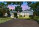 Lovely home with a beautifully landscaped front yard, a paved driveway, and a picturesque sunset backdrop at 601 75Th St N, St Petersburg, FL 33710