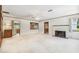 Open living room with a decorative fireplace, a ceiling fan, and a view of the kitchen at 601 75Th St N, St Petersburg, FL 33710