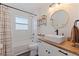 Bright bathroom featuring a modern vanity with a vessel sink, a round mirror, and tiled shower-tub combo at 642 14Th S Ave, St Petersburg, FL 33701
