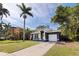 Charming single-story home featuring a large palm tree, well-manicured lawn, and inviting yellow front door at 642 14Th S Ave, St Petersburg, FL 33701