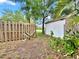 Backyard with a wooden fence, shed, and glimpses of a serene lake at 6700 14Th N St, St Petersburg, FL 33702