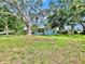 Quaint blue single-story house surrounded by lush greenery and mature trees at 6700 14Th N St, St Petersburg, FL 33702
