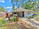 Inviting home exterior with a covered parking area, lush landscaping, and a welcoming red front door at 6700 14Th N St, St Petersburg, FL 33702
