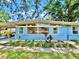 Charming blue home featuring a well-manicured garden, a front door, and unique architectural details at 6700 14Th N St, St Petersburg, FL 33702