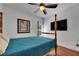 Bedroom boasts hardwood floors, a four-poster bed, ceiling fan, and mounted TV at 746 Coral Reef Dr # 746, Tampa, FL 33602