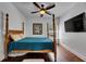Bedroom boasts hardwood floors, a four-poster bed, ceiling fan, and mounted TV at 746 Coral Reef Dr # 746, Tampa, FL 33602