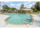 Enjoy the community pool with an easy access ladder and surrounding green spaces on a sunny day at 7833 Ontario Street Cir, Sarasota, FL 34243