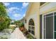 Charming home exterior with lush landscaping, brick pathway, and decorative windows at 7833 Ontario Street Cir, Sarasota, FL 34243