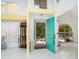 Bright foyer featuring a vibrant turquoise door, white tile floors and abundant natural light at 7833 Ontario Street Cir, Sarasota, FL 34243