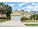 Charming yellow home featuring a two-car garage, well-maintained landscaping and a welcoming front entrance at 7833 Ontario Street Cir, Sarasota, FL 34243