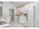 Bright white kitchen features modern appliances, tile floors, and plenty of cabinet space for storage at 7833 Ontario Street Cir, Sarasota, FL 34243
