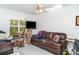 Living room featuring a ceiling fan, natural lighting, and a leather sofa at 7833 Ontario Street Cir, Sarasota, FL 34243