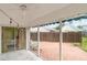 Enclosed patio area with brick floors, ceiling fan, string lights, and backyard views at 7833 Ontario Street Cir, Sarasota, FL 34243