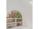 Arched window with mullions offers beautiful landscaping and a view of the home's brick exterior at 7833 Ontario Street Cir, Sarasota, FL 34243