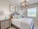 Charming bedroom featuring a decorative light fixture, a comfortable bed, and a window offering a pleasant outdoor view at 7881 Lakes Edge Ln, Port Charlotte, FL 33981