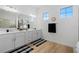 Bright bathroom with double sinks, white cabinets, a large mirror, and stylish decor at 7922 Lakes Edge Ln, Port Charlotte, FL 33981