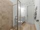 Stylish bathroom featuring a glass-enclosed shower with beige tiles and a white vanity with decorative accents at 7922 Lakes Edge Ln, Port Charlotte, FL 33981