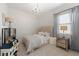 Cozy bedroom features a tufted headboard, chandelier and soft color palette at 7922 Lakes Edge Ln, Port Charlotte, FL 33981